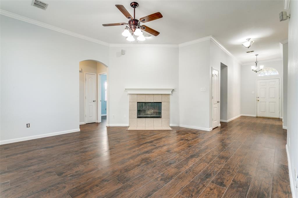 2408 Graystone Lane Corinth, TX 76210 - Photo 8 of 17 an empty room with fan and a fireplace