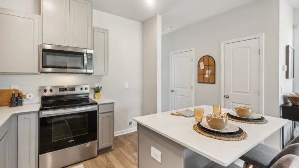 a kitchen with a stove a microwave and cabinets