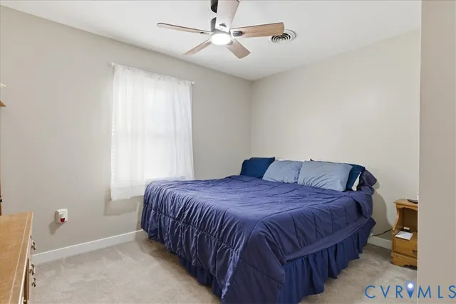 a bedroom with a bed wooden floor and flat screen tv