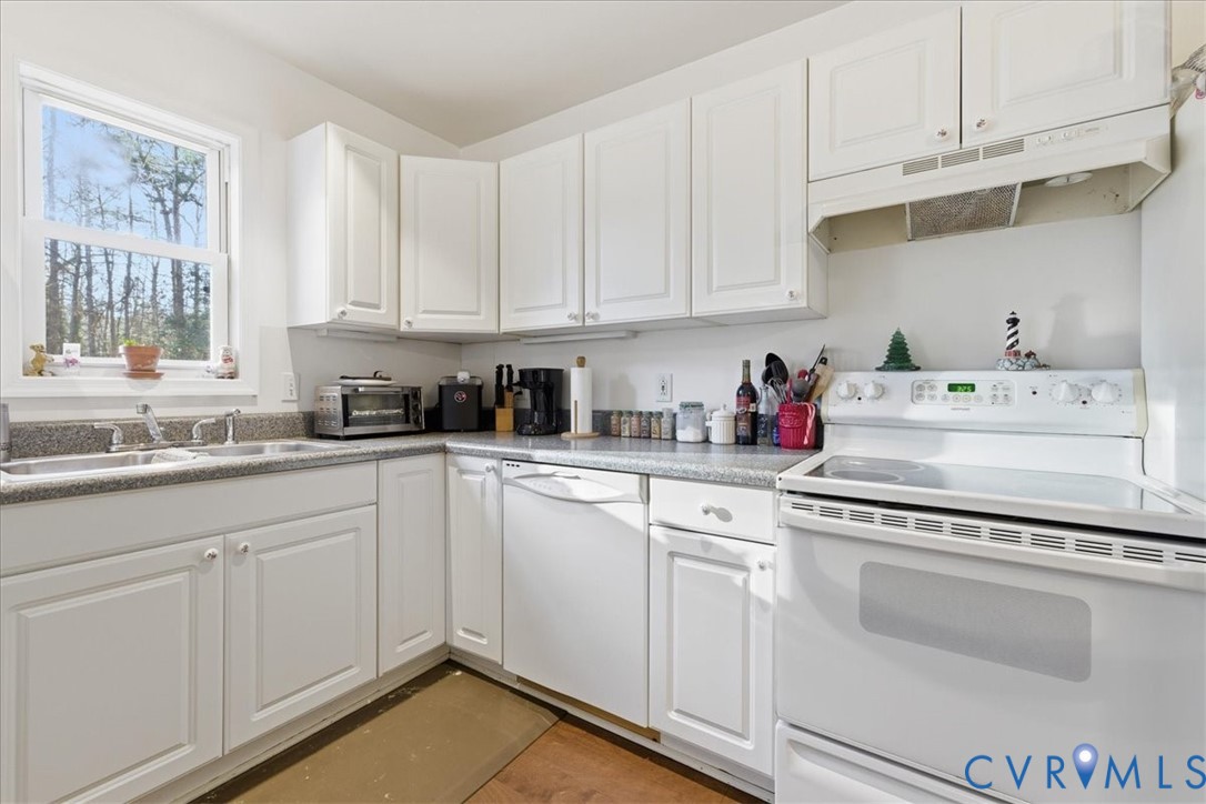13504 Taylor Drive Disputanta, VA 23842 - Photo 23 of 49 a kitchen with white cabinets and white appliances