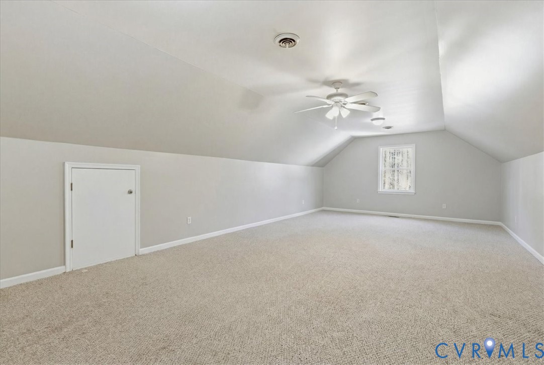 13504 Taylor Drive Disputanta, VA 23842 - Photo 28 of 49 an empty room with a chandelier fan and windows
