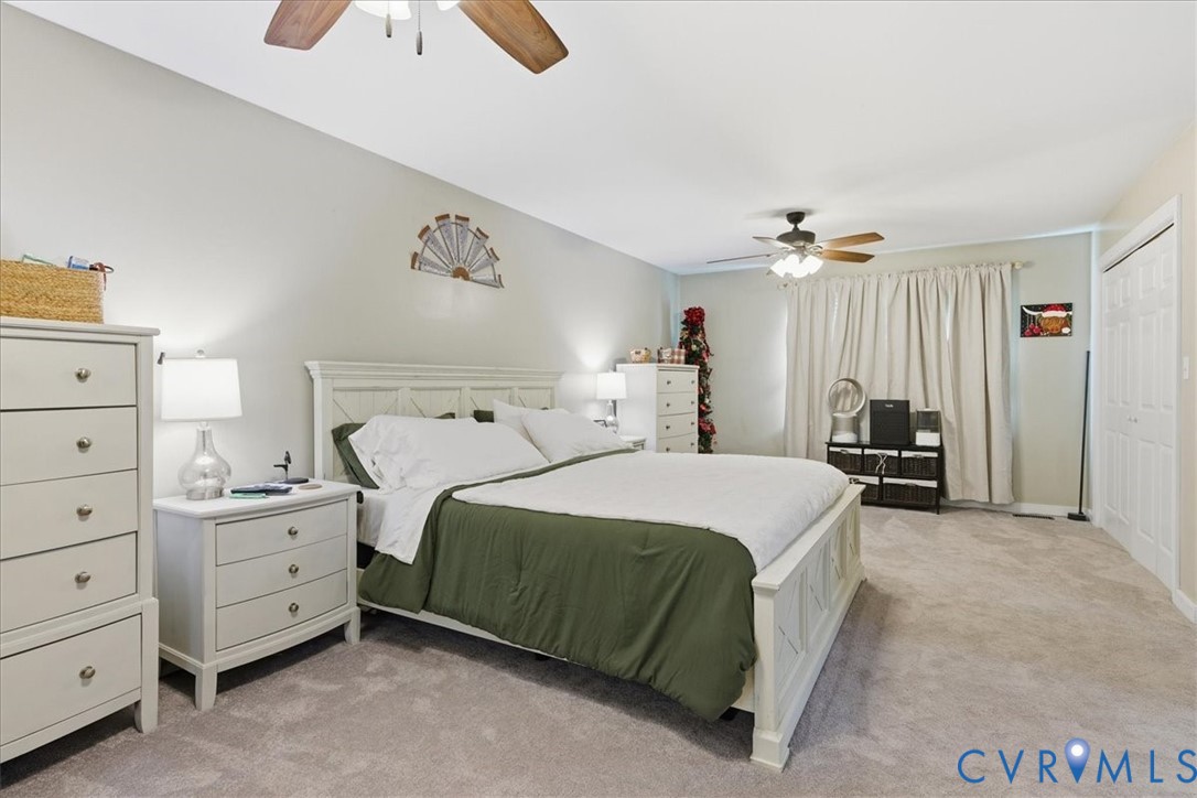 13504 Taylor Drive Disputanta, VA 23842 - Photo 40 of 49 a bedroom with a bed and a chandelier