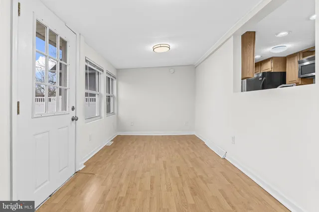a view of a room with wooden floor and white walls