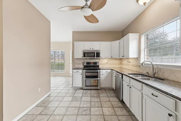 a kitchen with stainless steel appliances a stove a sink and a microwave