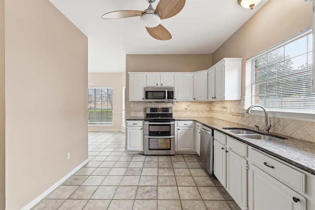 605 Andover Lane Coppell, TX 75019 - Photo 14 of 39 a kitchen with stainless steel appliances a stove a sink and a microwave