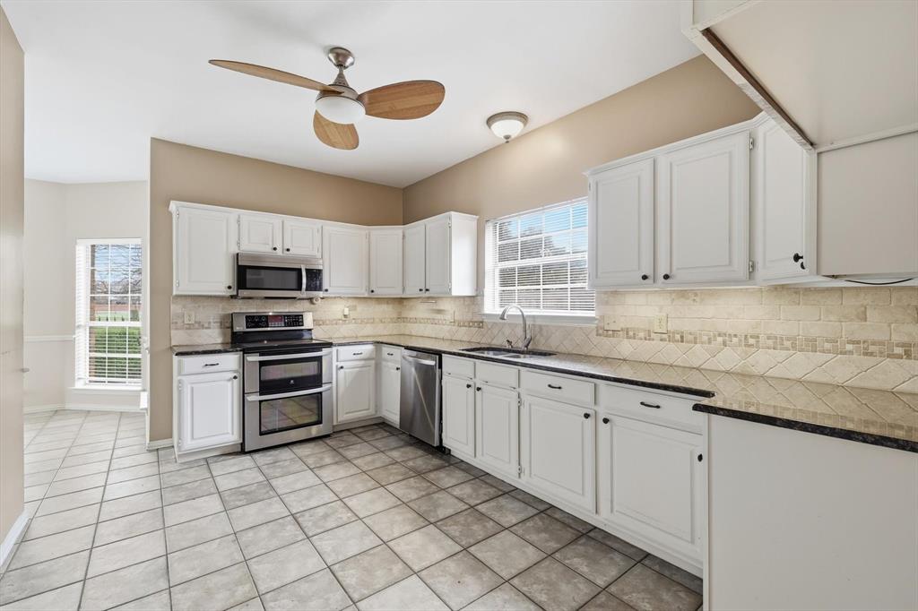605 Andover Lane Coppell, TX 75019 - Photo 15 of 39 a kitchen with granite countertop a stove a sink and a refrigerator