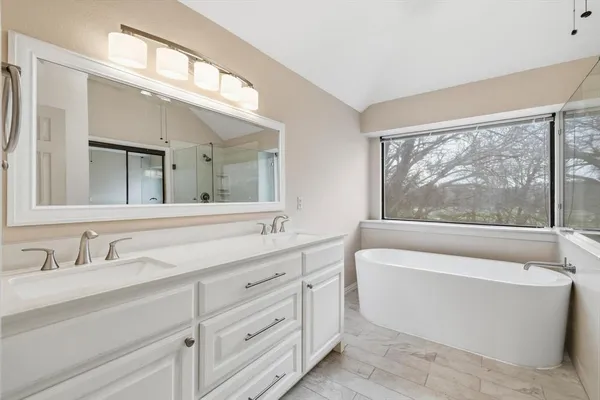 a bathroom with a large tub sink and mirror