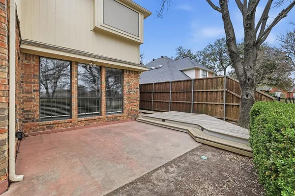 a view of a house with a large window and wooden fence