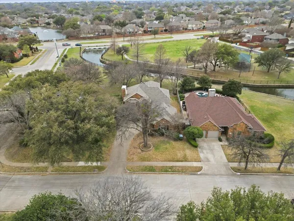 an aerial view of residential houses with outdoor space and lake view