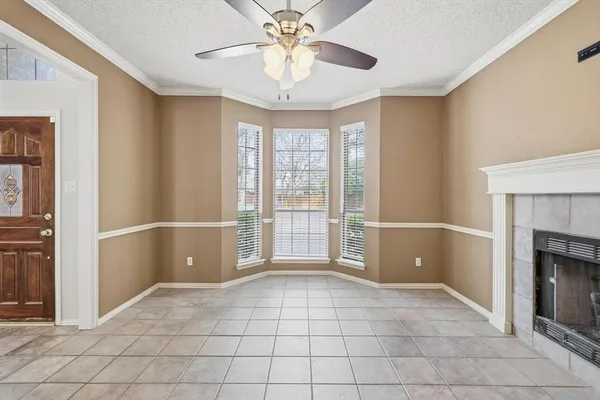a view of an empty room with window and chandelier fan