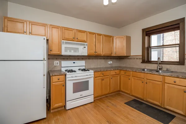 a kitchen with stainless steel appliances granite countertop a stove a sink dishwasher a refrigerator and a microwave