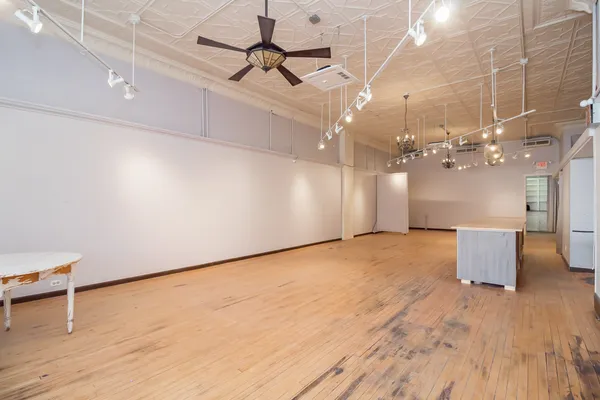 a view of a room with wooden floor and ceiling fan