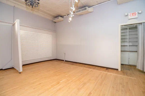 an empty room with a ceiling fan and windows