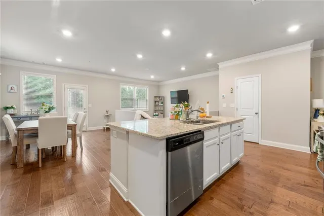 a kitchen with center island with sink stainless steel appliances and dining table