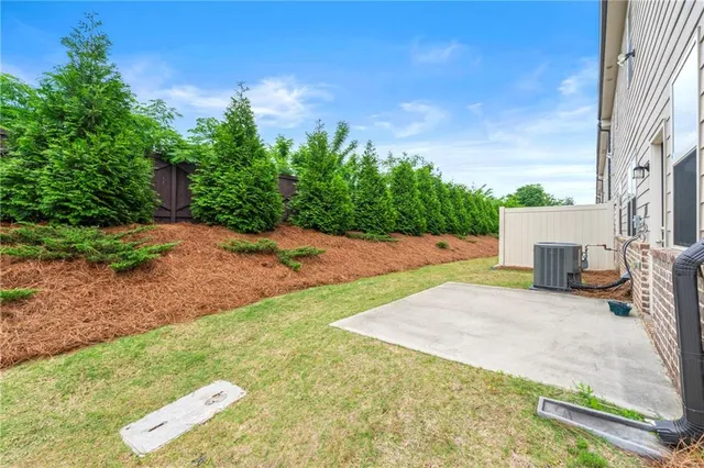 a view of a backyard with plants and a large tree