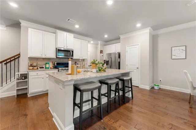 a kitchen with kitchen island a white counter top space cabinets and stainless steel appliances
