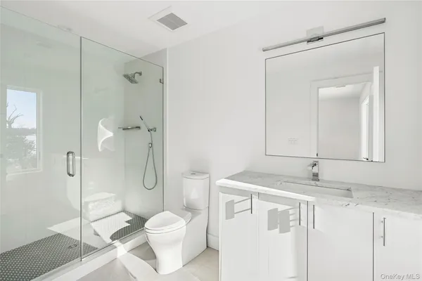 a bathroom with a granite countertop sink toilet and shower