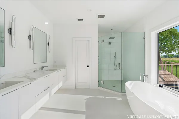 a spacious bathroom with a tub sink shower and mirror