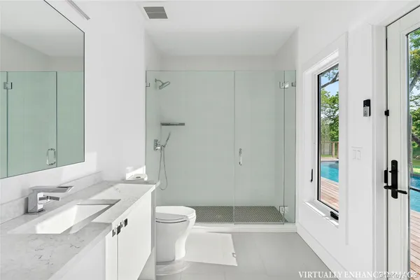 a bathroom with a granite countertop sink a toilet and shower