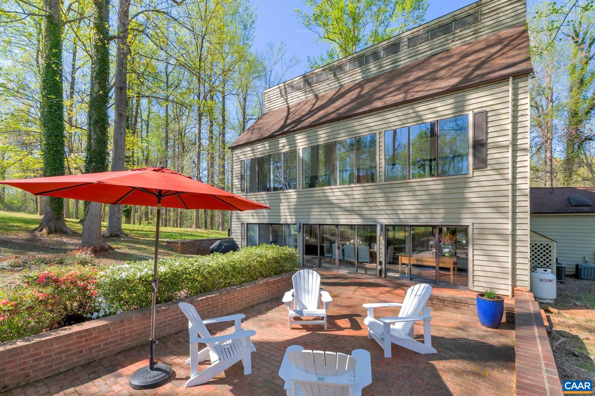 1050 Old Garth Road Charlottesville, VA 22901 - Photo 8 of 48 a view of a patio with couches table and chairs under an umbrella