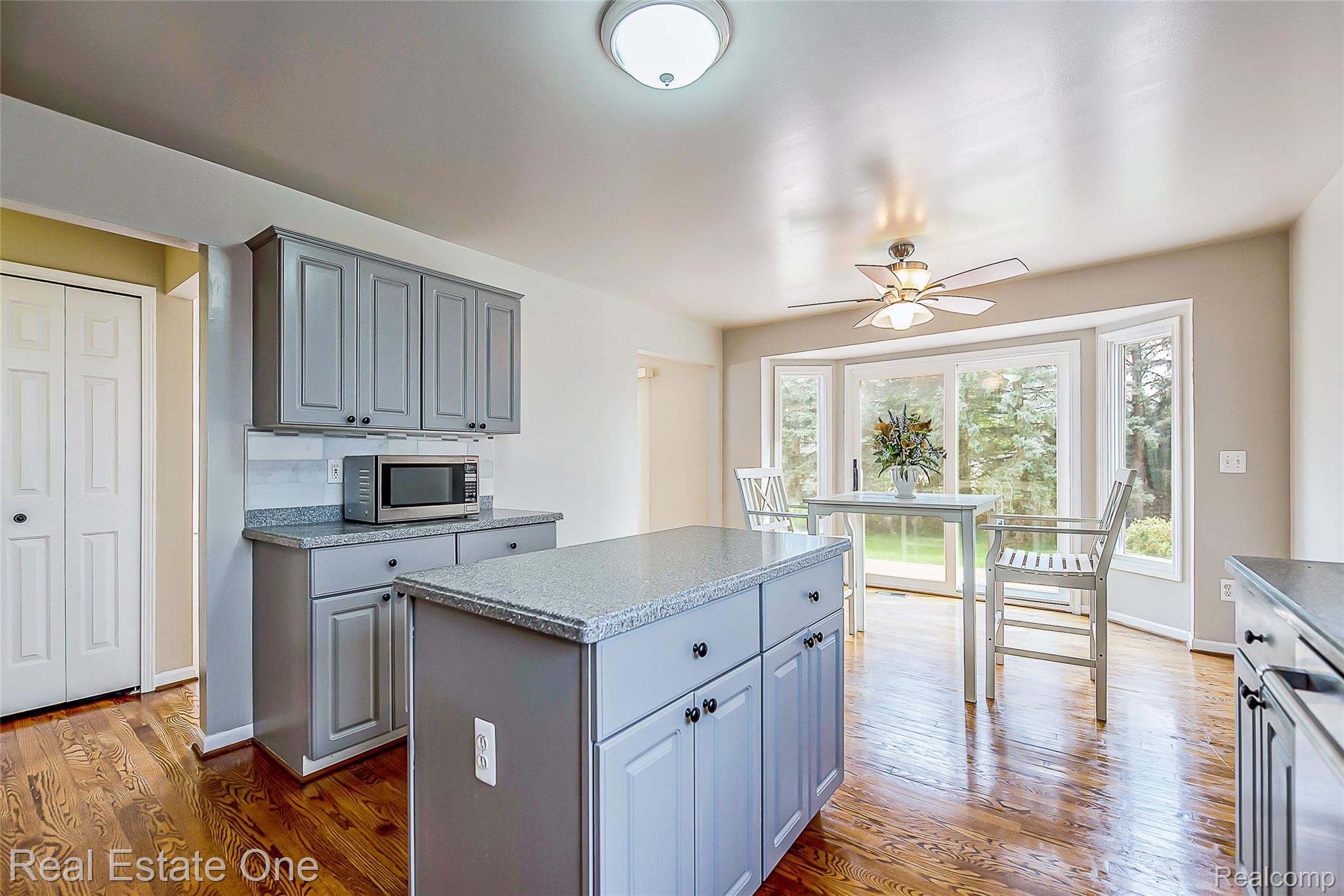 1013 Rochelle Park Drive Rochester, MI 48307 - Photo 20 of 74 Wood-finish flooring with grey cabinetry, granite-finish countertops, and a full-sized bay window