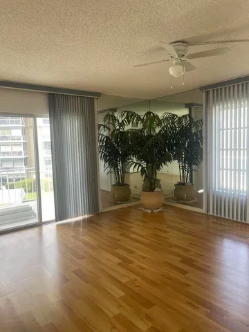 a view of a room with wooden floor and front door