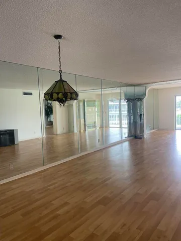 a view of empty room with wooden floor and ceiling fan