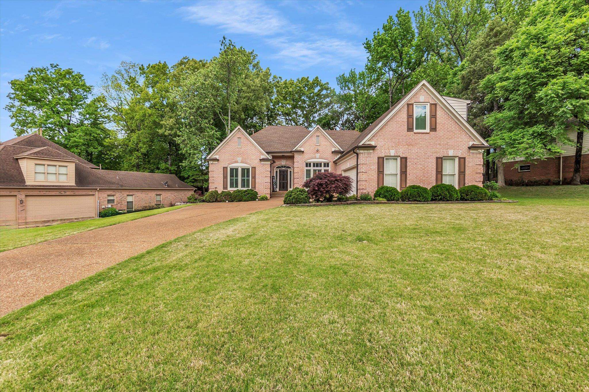 8786 Stablemill Lane Memphis, TN 38016 - Photo 1 of 40 a front view of a house with a garden and trees