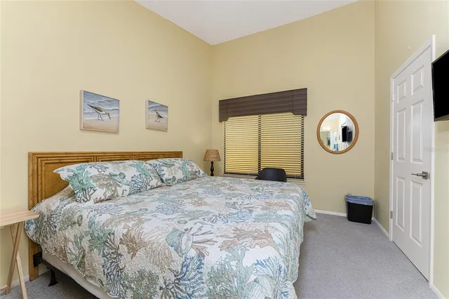 a bedroom with a bed a flat screen tv and a window