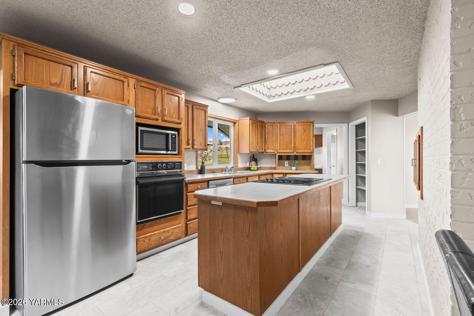 2030 Sunset Way Cowiche, WA 98923 - Photo 12 of 57 a kitchen with stainless steel appliances granite countertop a refrigerator a stove a sink dishwasher and a refrigerator with wooden floor