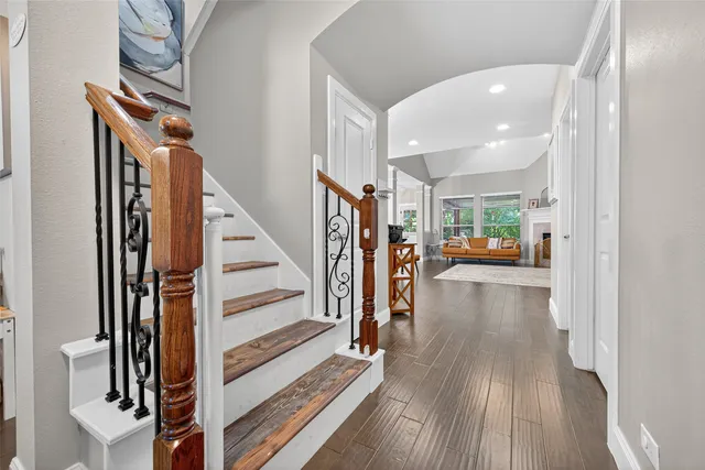 a view of a hallway with wooden floor and staircase