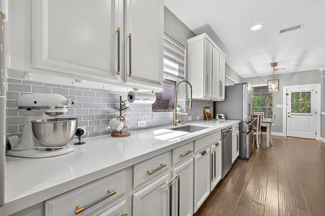 a kitchen with sink a stove and cabinets