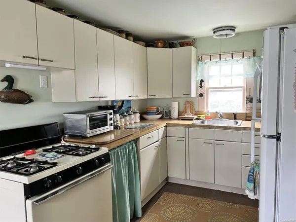 a kitchen with cabinets appliances and a window