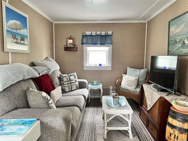 a living room with furniture a flat screen tv and a window