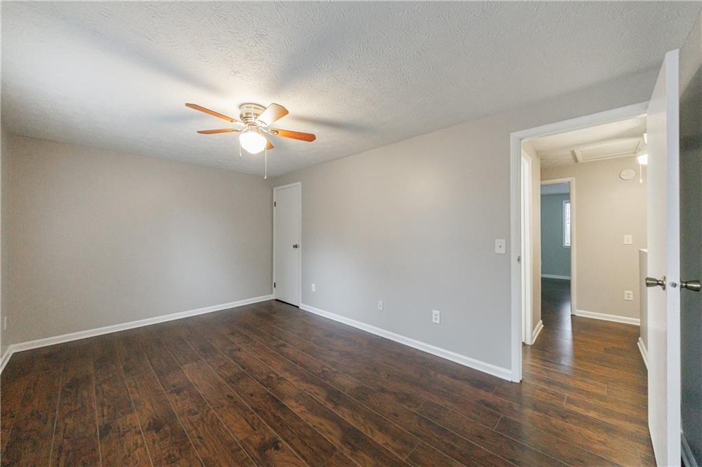 1960 Hamilton Place Southeast Marietta, GA 30067 - Photo 13 of 22 an empty room with wooden floor and a ceiling fan