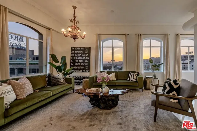 a living room with furniture flat screen tv and a large window