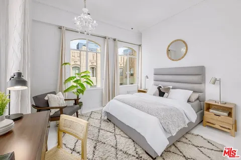 a bedroom with a bed mirror and furniture