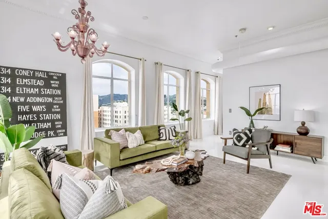 a living room with furniture a chandelier and a flat screen tv