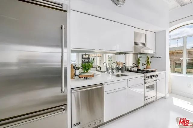 a kitchen with white cabinets and white appliances