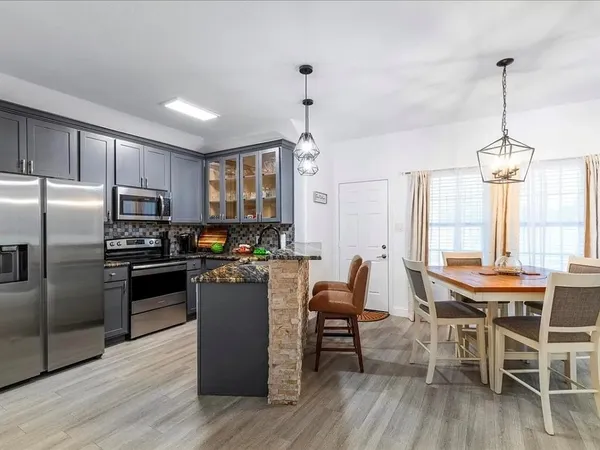 a kitchen with a table chairs refrigerator and cabinets
