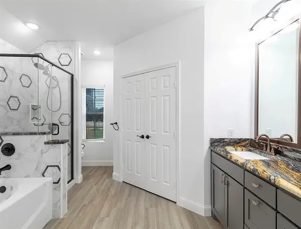 a bathroom with a granite countertop sink toilet and shower