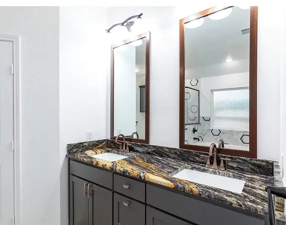 a bathroom with a granite countertop sink and a mirror