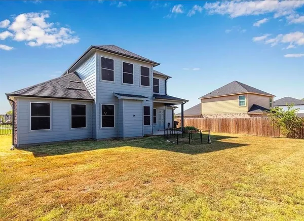 a view of a house with backyard and sitting area