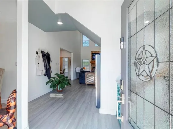 a hallway with wooden floor and potted plant