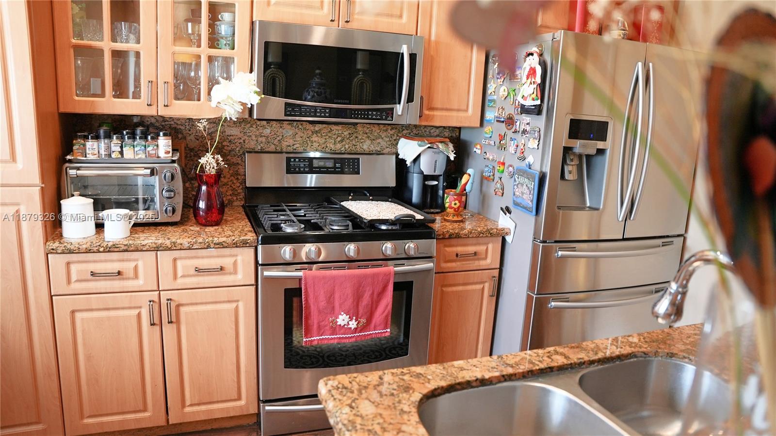 14856 Southwest 174th Street Miami, FL 33187 - Photo 15 of 31 a kitchen with stainless steel appliances granite countertop a refrigerator stove and sink