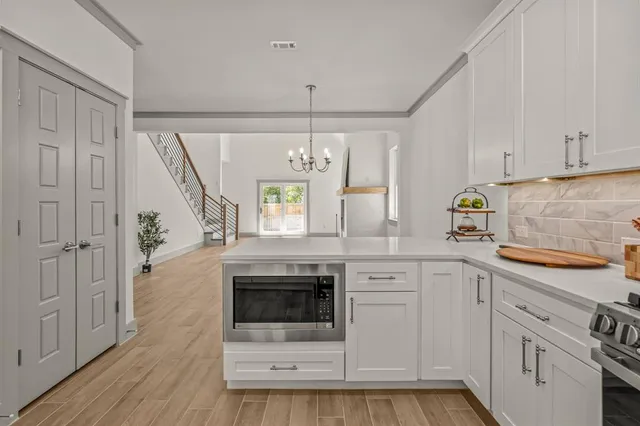 a kitchen with stainless steel appliances granite countertop a stove and white cabinets