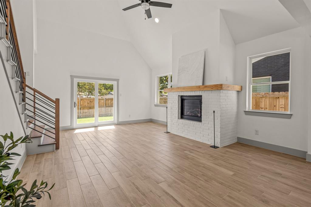 5817 Coleman Street Westworth Village, TX 76114 - Photo 13 of 40 an empty room with wooden floor a fireplace and windows