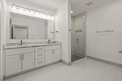 a spacious bathroom with a shower sink double and mirror