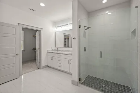 a spacious bathroom with a shower a sink and mirror