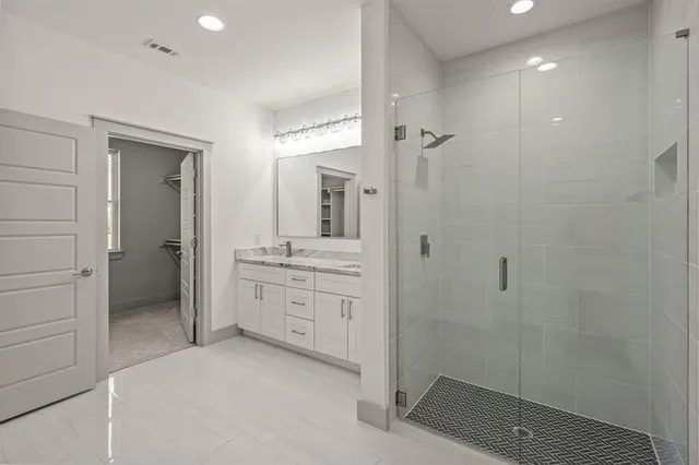 a spacious bathroom with a shower a sink and mirror